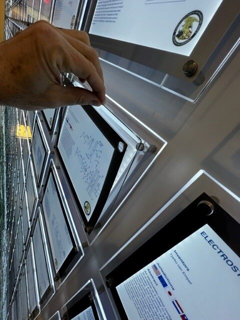 Hand holding an iPad near a door with a sticker about Wi-Fi.